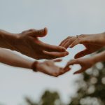 two people touching fingertips with both hands