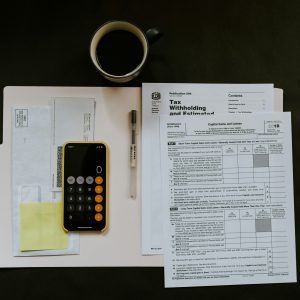 tax documents and a phone calculator on a black tabletop